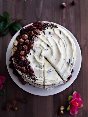 a flat lay of a cake with nut decoration and white frosting