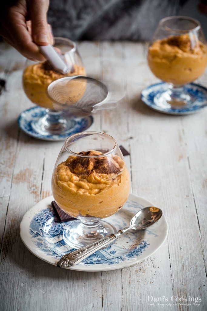sweet potato mousse being sprinkled with cocoa powder