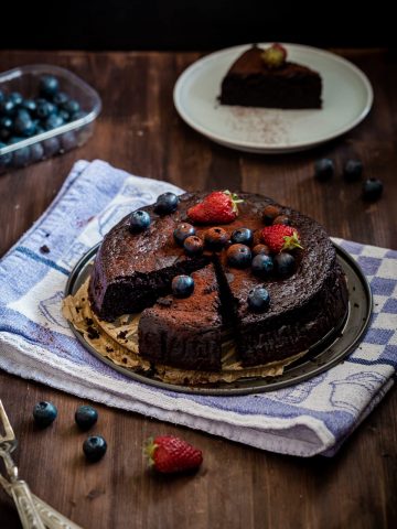 sliced chocolate flourless cake with berries