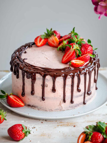 A Chocolate drip cake with strawberry frosting
