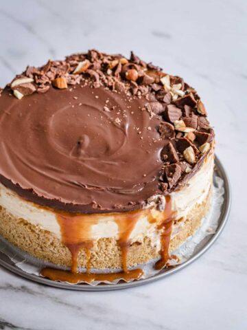 a cheesecake with chocolate on top and dripping caramel under