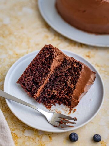 a slice of chocolate cake with frosting, eaten with a fork