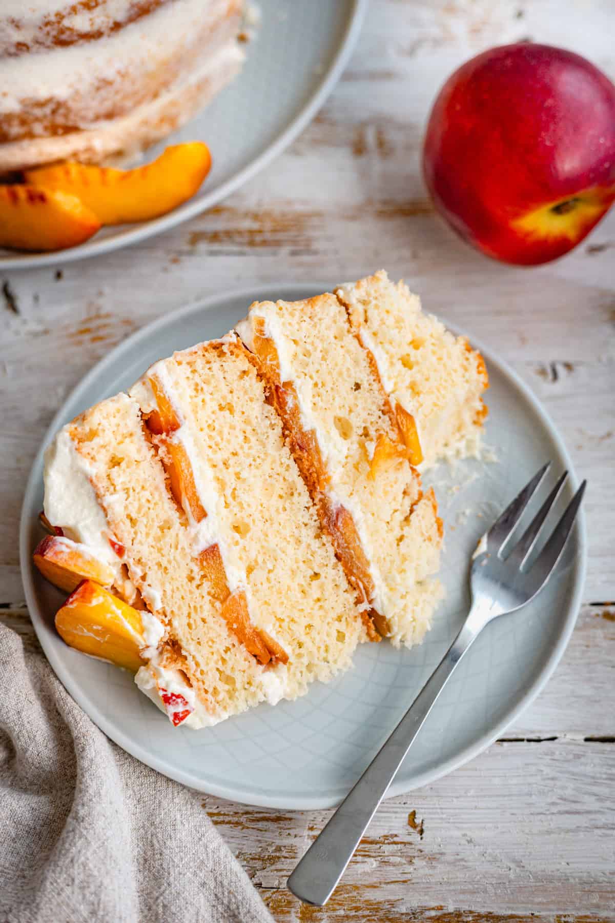 a slice of peach chiffon cake, a bite taken with a fork